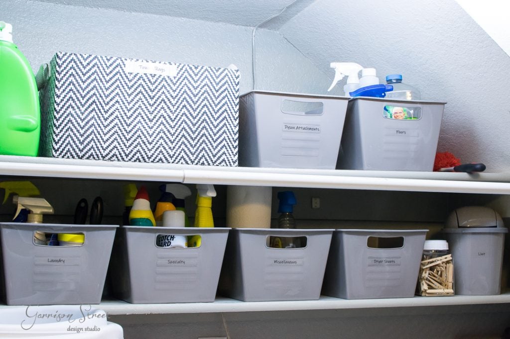 Home Effortlessly enhance room organization with storage shelves featuring labeled grey bins and a decorative box. The top shelf holds bins for "Floor Protectors" and "Floor", along with cleaning supplies, while the bottom offers tidy sections for "Laundry", "Solutions", "Miscellaneous", and "Shoe Care".
