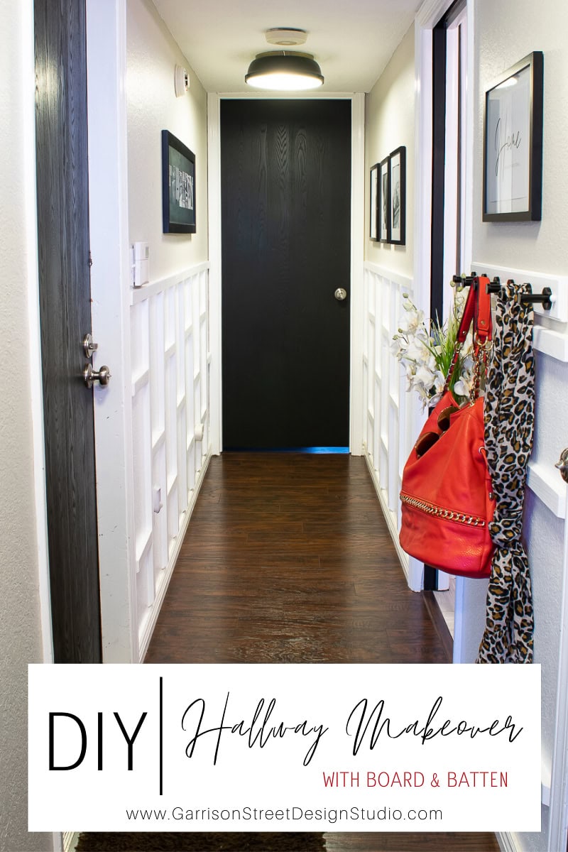 A modern hall featuring white board and batten walls and dark wood flooring leads to a black door. Decor includes hanging frames and a wall-mounted hook with a red bag and leopard-print scarf. Text overlay reads, "DIY Hallway Makeover with Board & Batten.