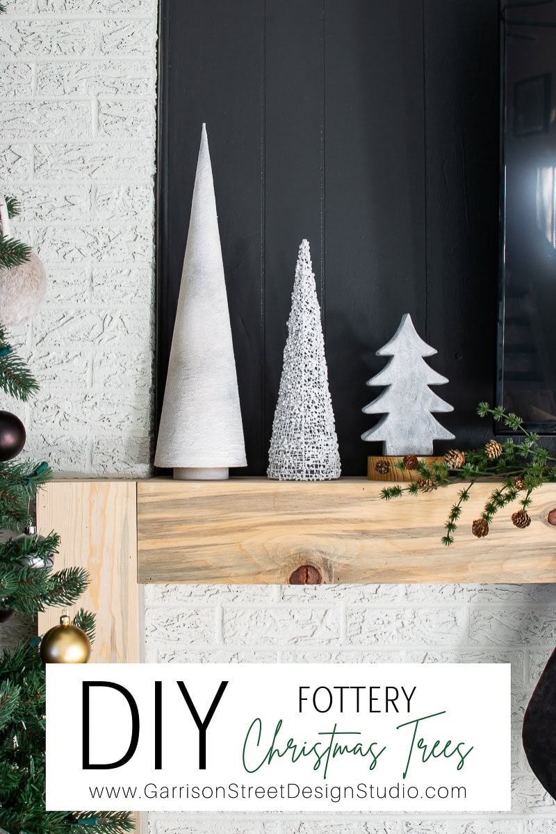 A modern mantel showcases three Fottery Christmas trees: a tall cone, a textured small cone, and a tree-shaped design. This charming setup sits elegantly beside a pine garland, with a website link below.