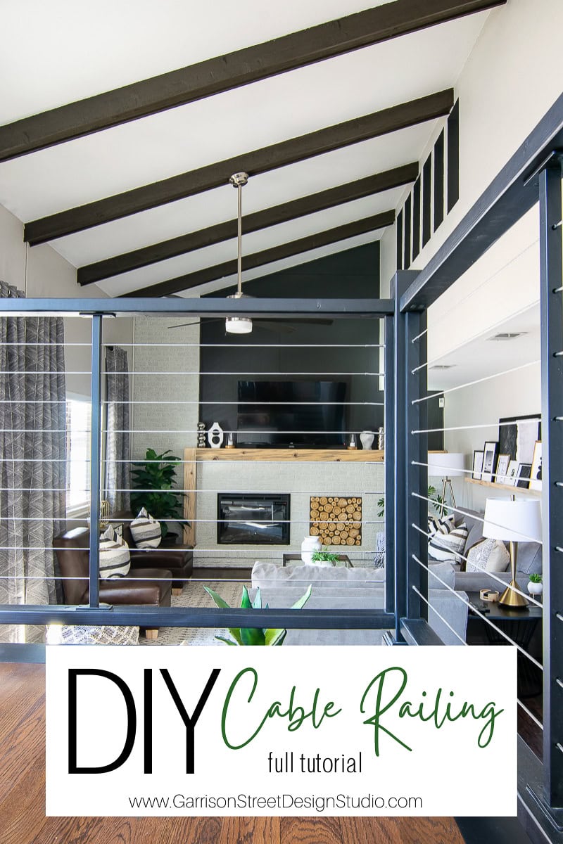 A modern living room showcases exposed wooden beams and a sleek cable railing, offering a perfect blend of contemporary and rustic decor. It features a built-in fireplace with stacked wood, a large flat-screen TV, and text overlay reads: "DIY Cable Railing Full Tutorial.