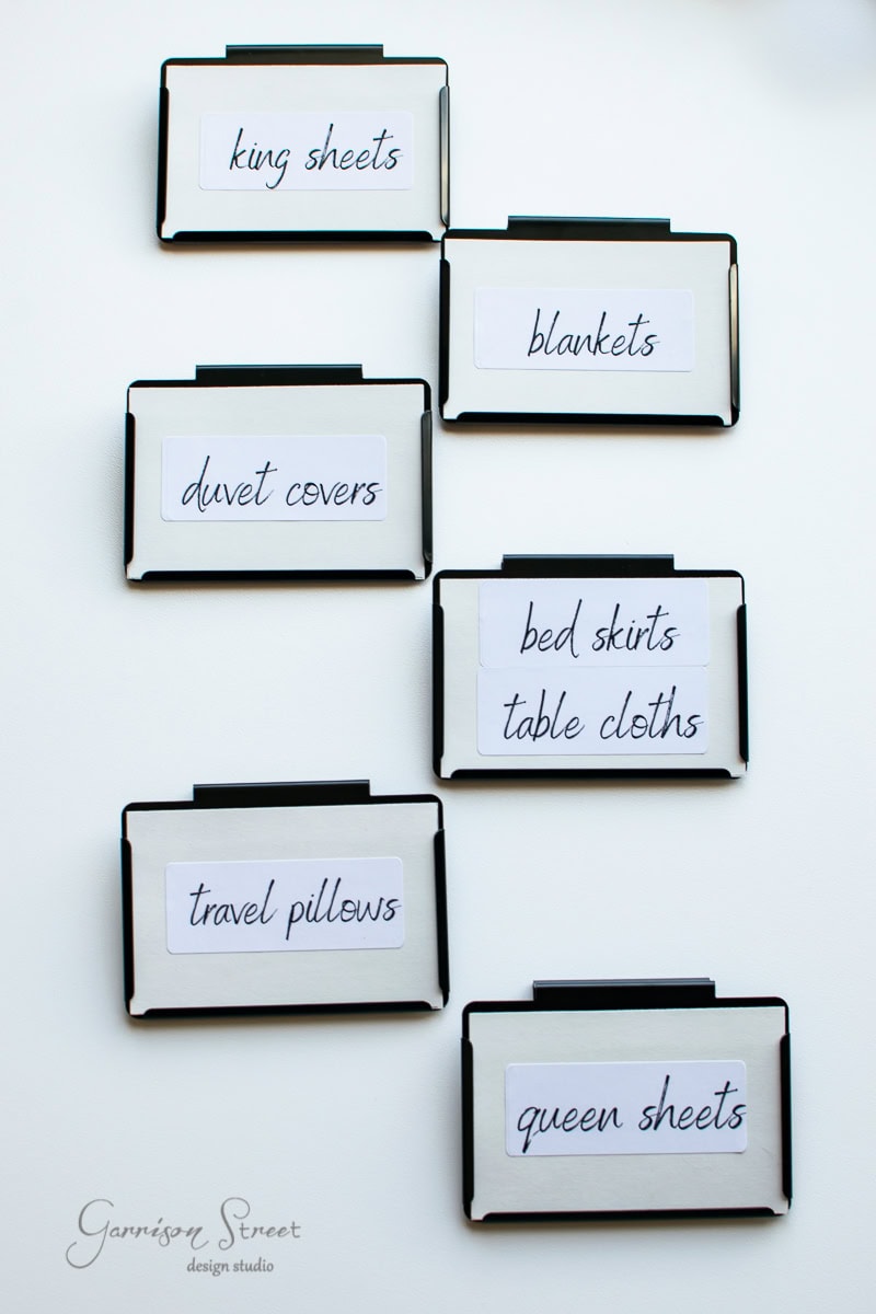 Labeled black clips displayed on a white surface. The labels read: king sheets, blankets, duvet covers, bed skirts/table cloths, travel pillows, and queen sheets.