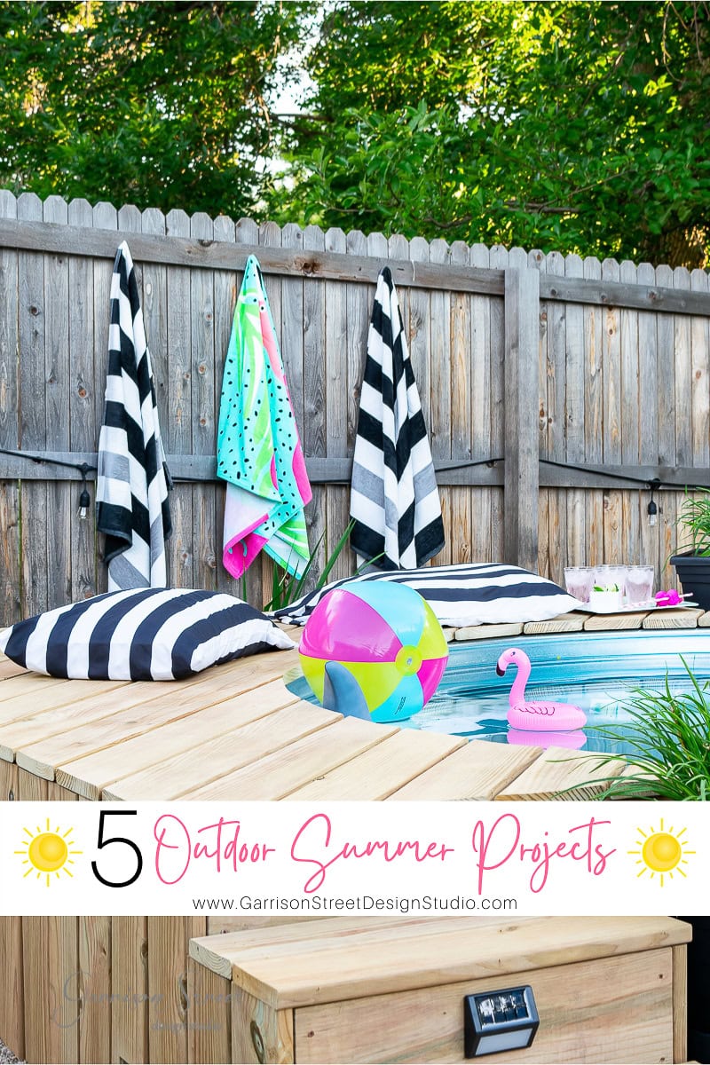 A small wooden deck with black and white striped cushions and towels hanging on a fence. A colorful beach ball and pink inflatable flamingo are placed on the deck, capturing the essence of summer living. Text on the image reads "5 Outdoor Summer Projects.