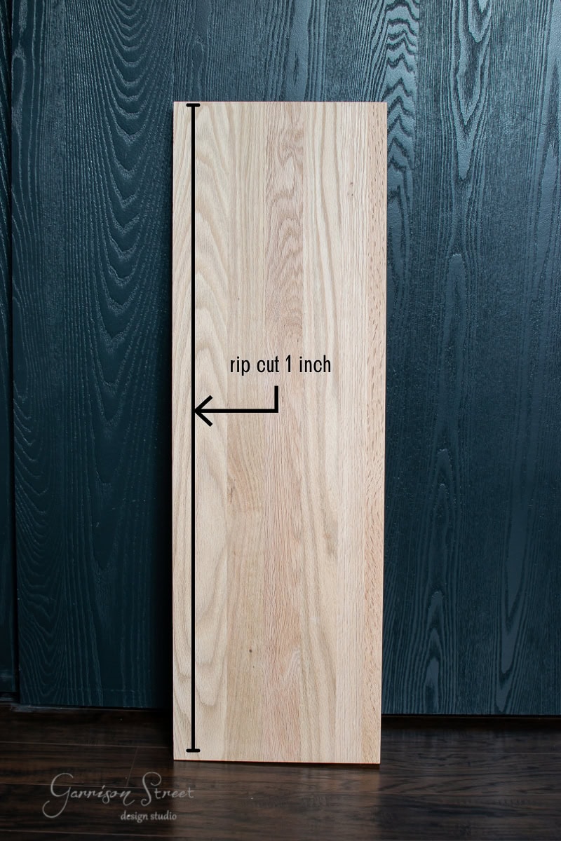 Wooden board against a dark textured background with the words "rip cut 1 inch" and a vertical line and arrow indicating the direction of the cut—perfect for crafting stair treads or risers. A logo is visible in the lower left corner.