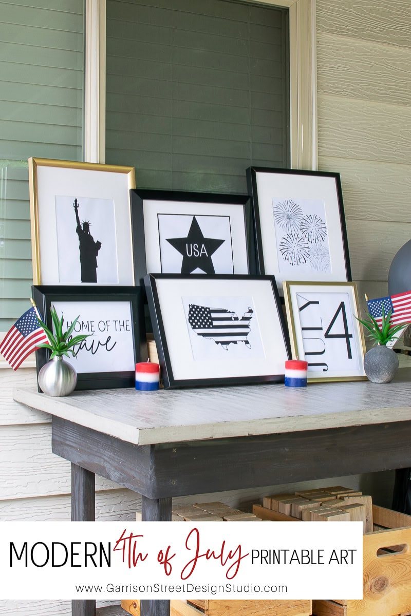 A stunning display of 4th of July printable art adorns the table, featuring a silhouette of the Statue of Liberty, a USA map, and vibrant fireworks. Completing the festive look are small American flags and red, white, and blue candles elegantly arranged around the scene.