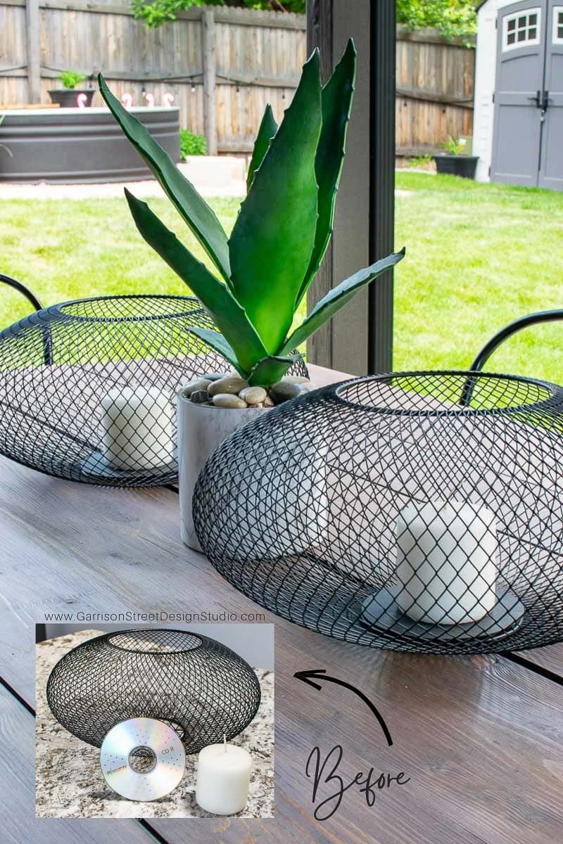 A patio table showcases two black wire candle holders, each cradling a white candle. A Luftmassa potted plant sits between them. An inset image compares a wire base with a CD and candle labeled "Before." The background reveals a lush lawn.