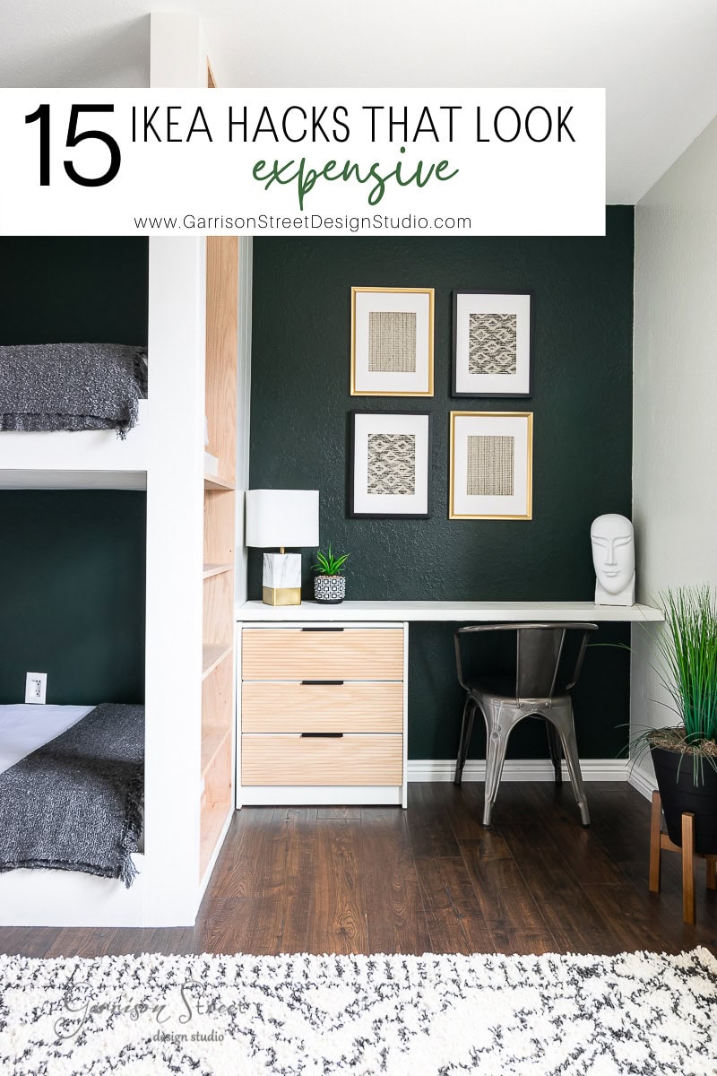 A modern room showcases a bunk bed on the left, alongside an IKEA hack: a sleek desk with a chair and drawer unit. The wall, painted dark green, is adorned with three framed pictures. A lamp and decorative items are strategically placed on the desk, creating an expensive look without breaking the bank.