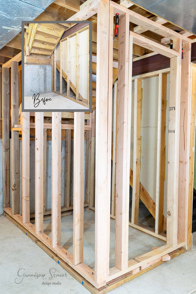 A wooden framing structure illustrates how to frame basement walls during construction within a building. An inset image labeled "Before" shows the area prior to construction, highlighting the progress. A logo reading "Garrison Street Design Studio" is visible in the lower left corner.