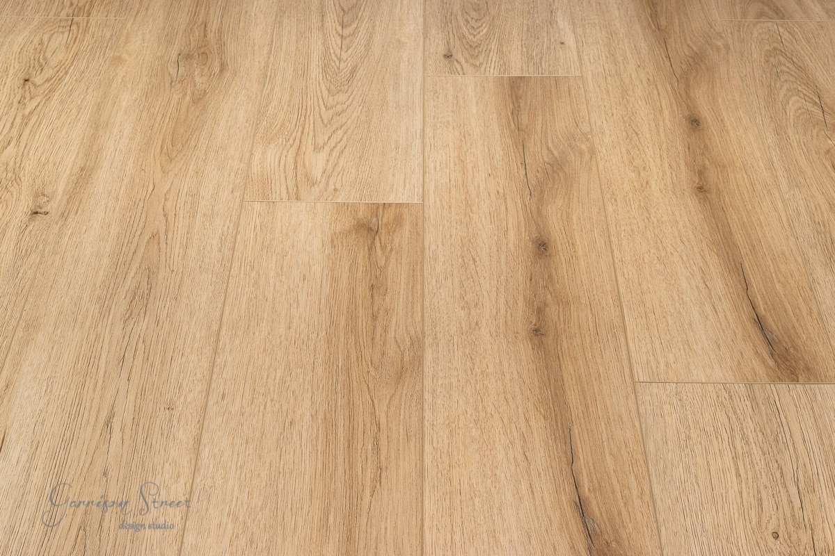 A wooden floor with a light oak finish. The planks boast a natural grain pattern and subtle knots, adding texture and warmth to the surface.