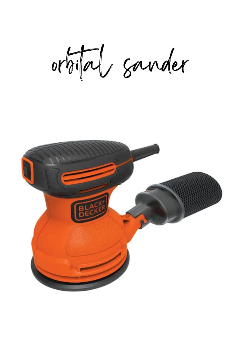 Image of an orange and black Black & Decker orbital sander. The tool features a round sanding pad and a dust collection bag, with the brand logo visible. The words "orbital sander" are elegantly written above the product.