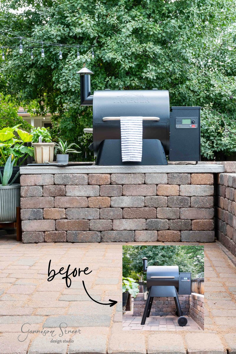 On a serene stone patio, a sleek black grill with a digital panel and chimney stands as the centerpiece of this DIY Traeger outdoor kitchen. A towel drapes from its handle, framed by lush greenery. An inset photo labeled "before" reveals the grill's humble beginnings. Text reads "Garrison Street Design Studio.