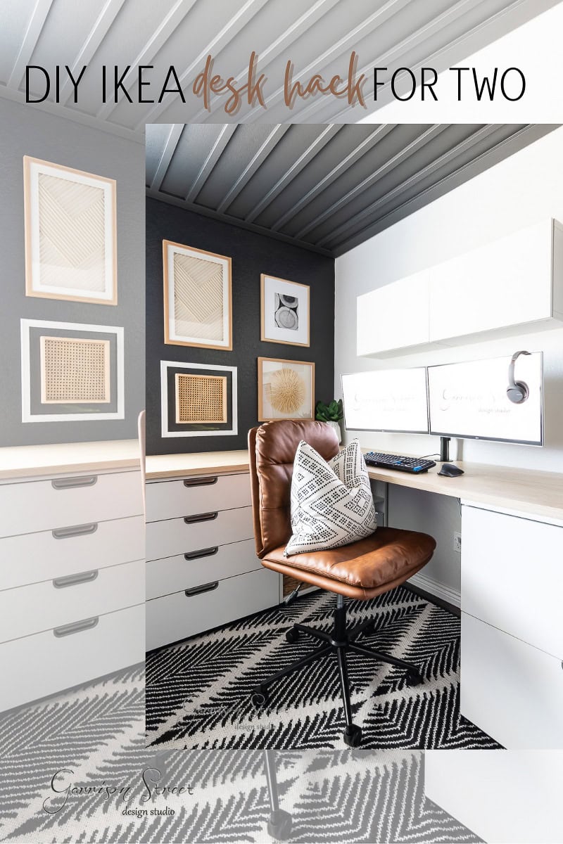 A modern DIY home office for two features a brown leather chair at a corner desk with white drawers. The walls are adorned with framed geometric art, and a patterned black and white rug covers the floor, creating a minimalist and stylish design.