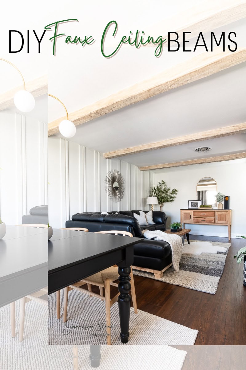 Stylish living and dining area with expertly crafted DIY faux ceiling beams, a black sectional sofa, and modern decor. A black dining table and chairs are in the foreground, with a wooden sideboard and large mirror at the back. The room features neutral colors and wood floors.