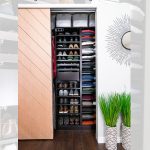 A neatly organized closet features sliding wooden doors, with shelves stacked with shoes, folded clothes, and accessories. A decorative mirror and a plant stand on the right. Text above reads: "DIY Custom Reach In Closet Makeover with IKEA PAX.