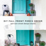 A teal front door with a welcome sign, fall-themed porch decor including orange pumpkins, black-and-white planters with greenery, black chairs with cushions, and a doormat on a white porch. Text reads: DIY Fall Front Porch Decor.
