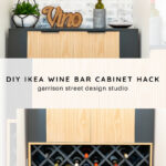 A modern wine bar cabinet with a crisscross wine rack filled with bottles sits against a white brick wall. Decor items, including a plant, a “Vino” sign, and bottles, are displayed on top. Text overlay reads: "DIY IKEA Wine Bar Cabinet Hack.