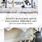 A Halloween display features black and white framed art with witches, spiders, eyes, and "Hocus Pocus" text. Decorative pumpkins, faux spider webs, and a plastic skeleton complete the spooky scene.
