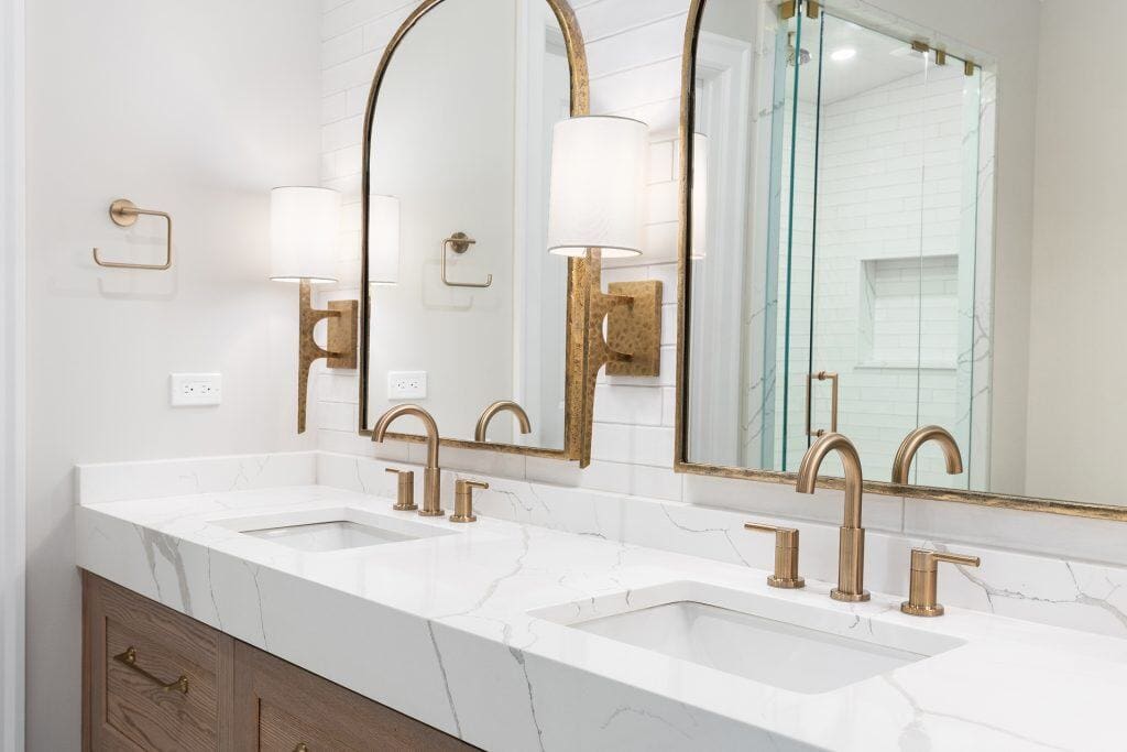Modern bathroom with double marble vanity and gold fixtures.