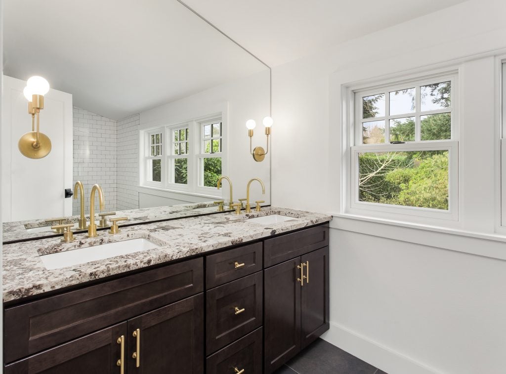 Granite kitchen countertops with gold fixtures and white walls.