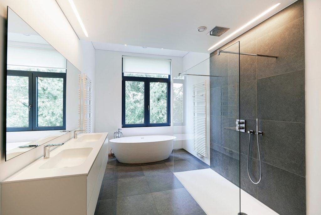 Bathroom with walk-in shower, bathtub, and large windows for natural light.