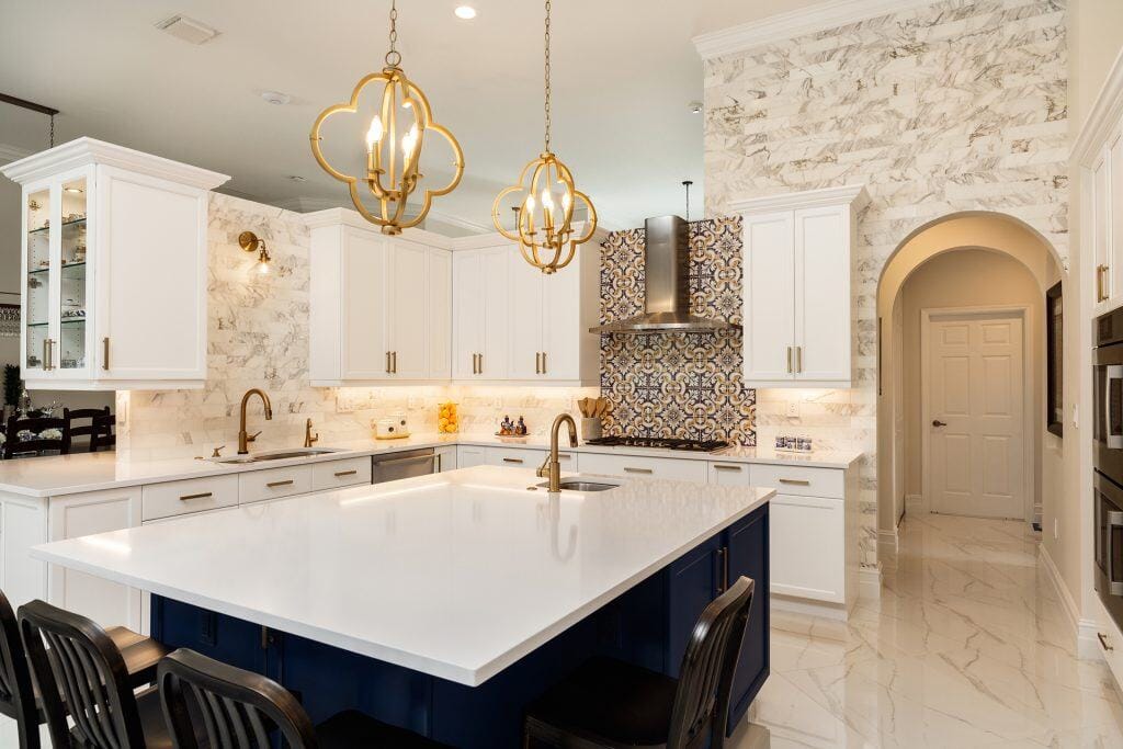 Elegant kitchen featuring white cabinets and a blue island with granite countertops.