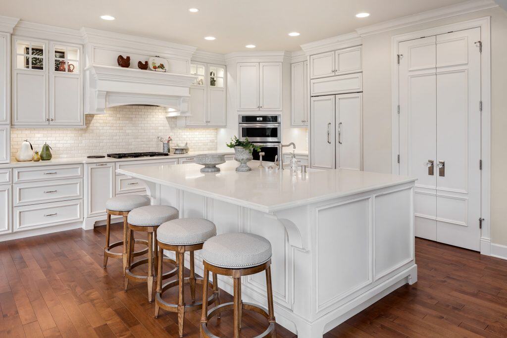 White kitchen with custom countertops and island design.