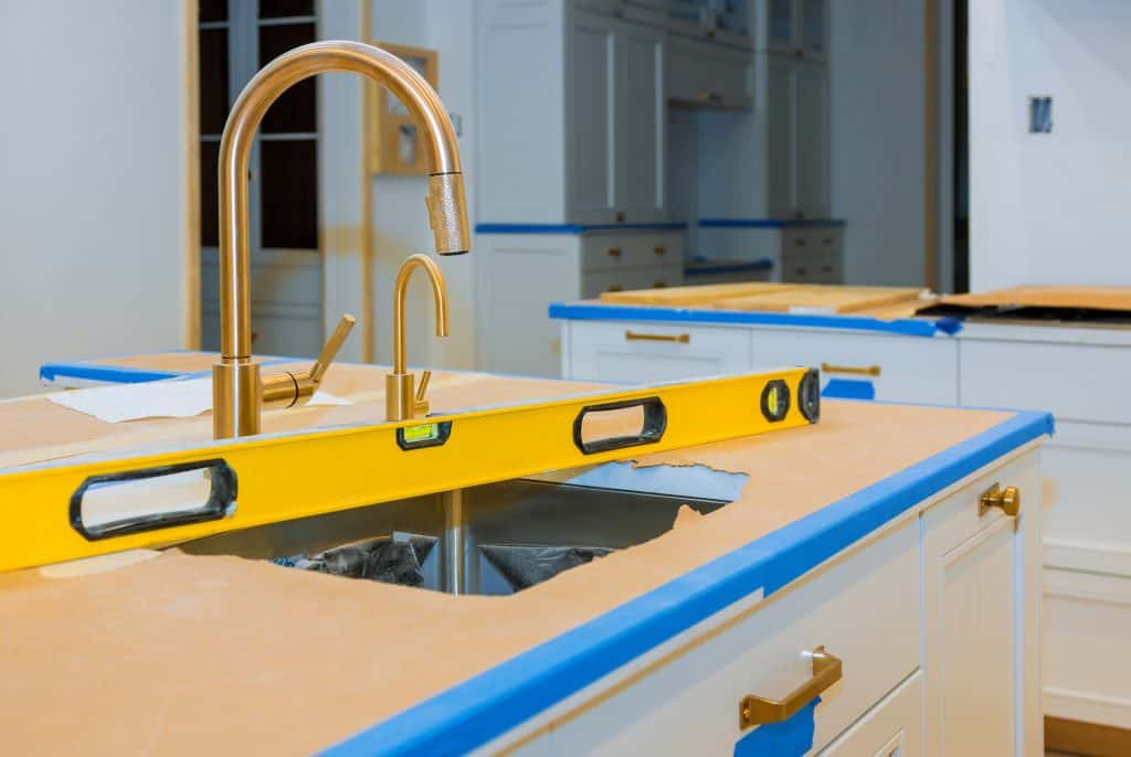 Countertop with gold faucet and blue accents in a modern kitchen.