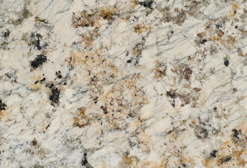 Granite countertop with a polished finish, showcasing natural beige, black, and gold speckles.