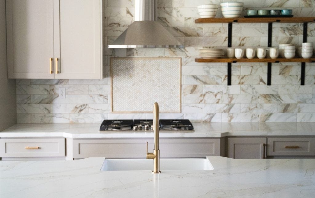Elegant marble countertops with sleek design and open shelving in a contemporary kitchen.
