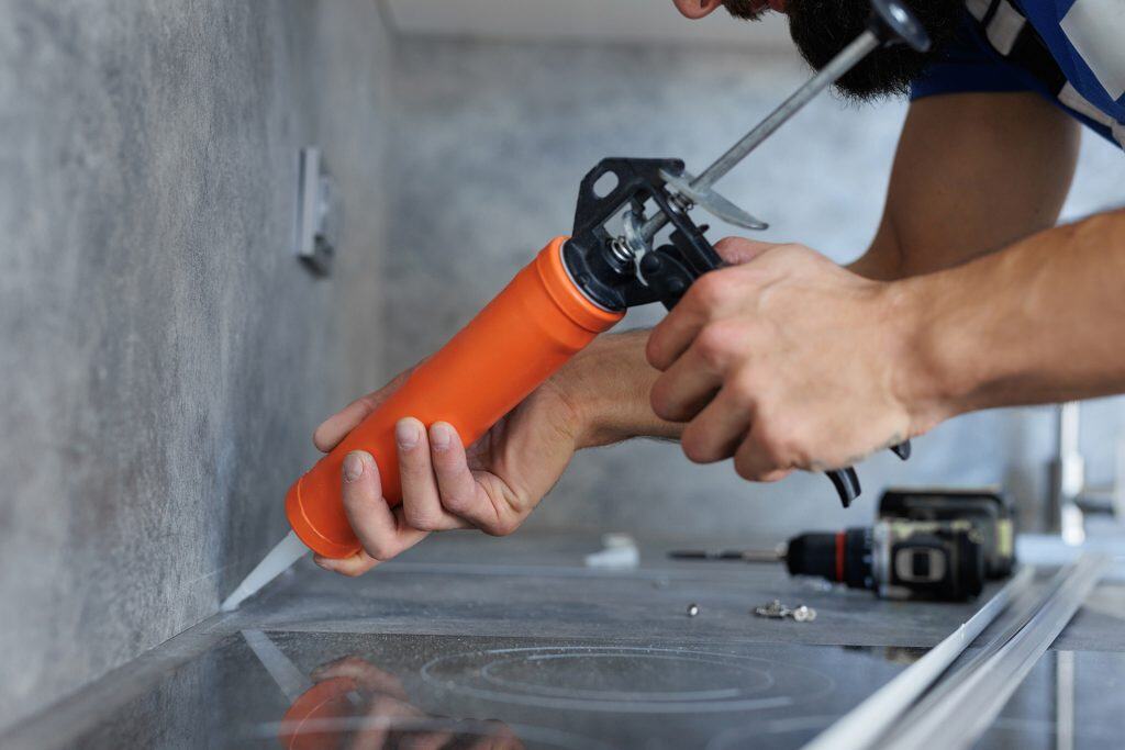 Caulking countertop edges for a seamless finish.
