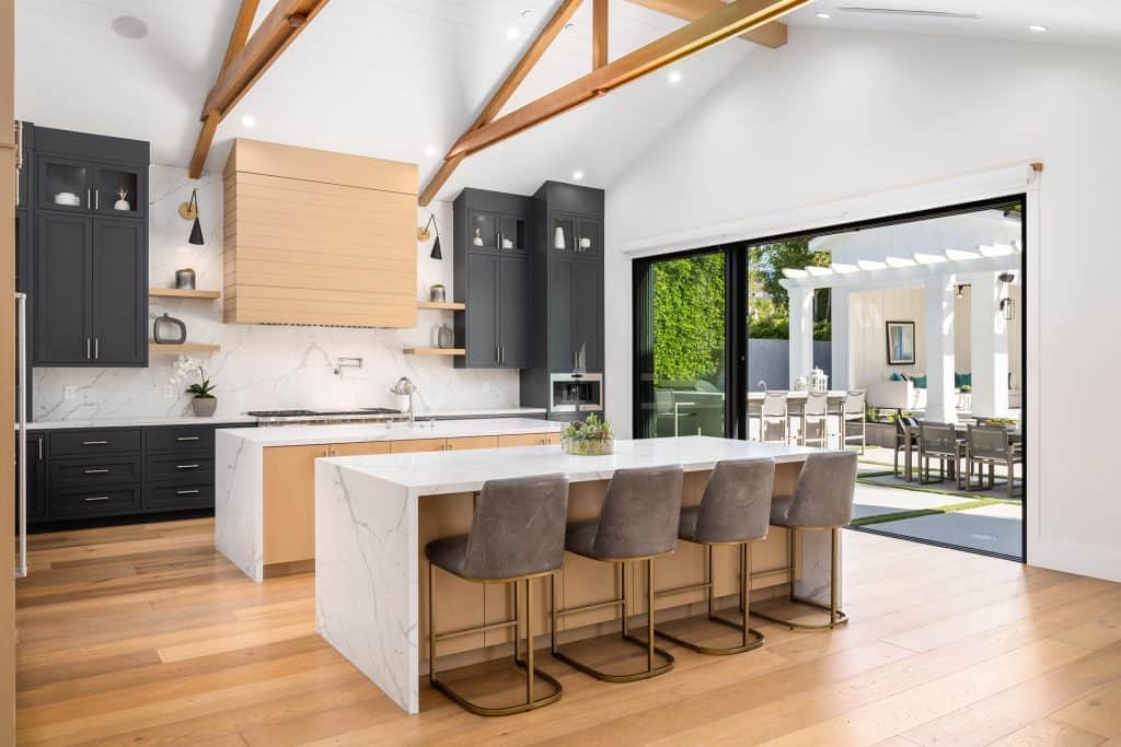 Quartz countertops with sleek black cabinetry and wooden beams in a contemporary kitchen setting.