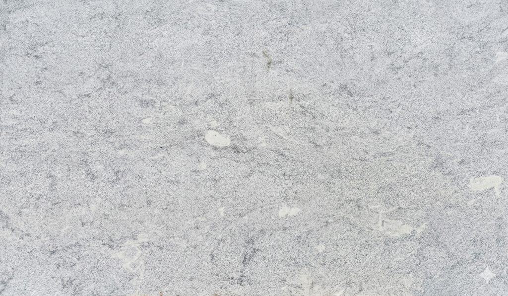 Alpha White quartz surface with subtle veining and smooth finish.