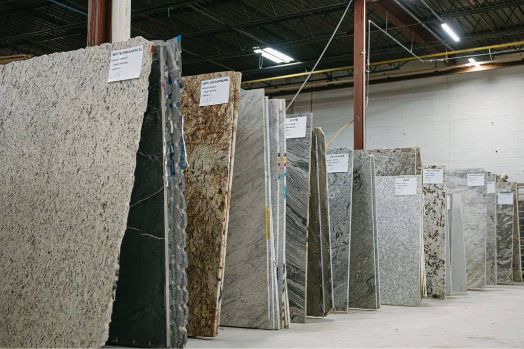 Variety of granite countertop samples in a warehouse setting.