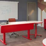 Office conference room with red furniture and whiteboard.