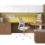 Office desk with computer, chair, and storage cabinets in a professional workspace.