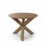 Wooden round table with crossed legs in a modern office setting.