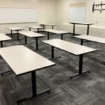 Classroom with white Huron tables and whiteboards on the wall.