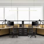Contemporary office with two workstations, chairs, and large windows.