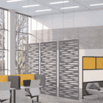 Spacious office with large windows, modern furniture, and decorative partitions.