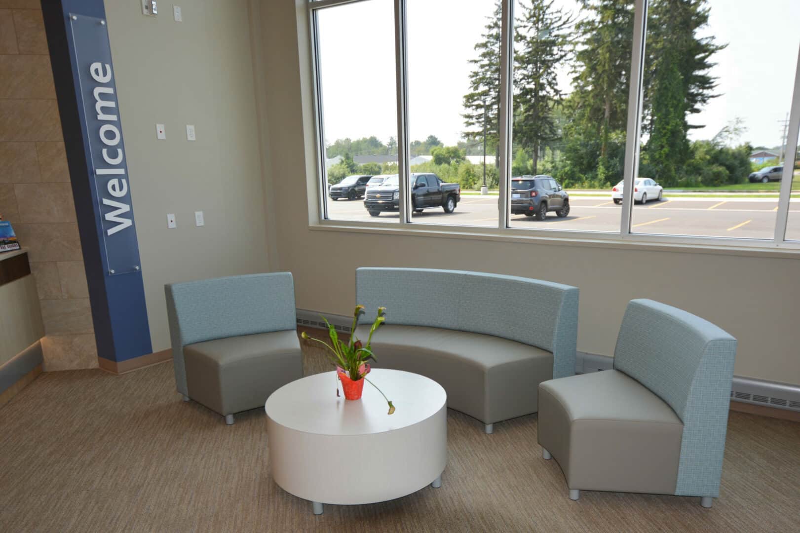 Modern office lobby with curved seating and large window view.
