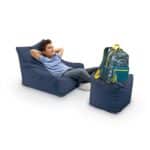 Child relaxing on bean bag with backpack nearby, outdoor scene.