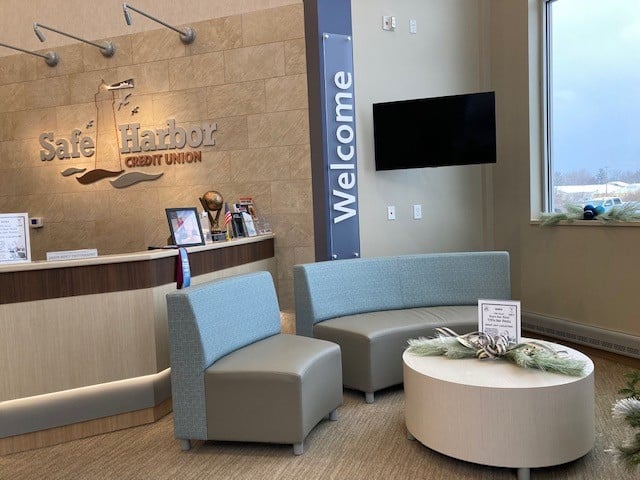 Modern office reception with seating, TV, and welcoming decor.
