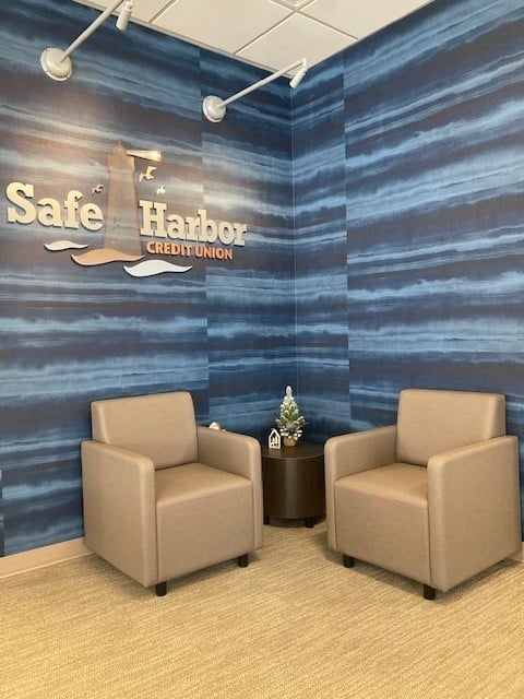 Comfortable seating area with two beige armchairs and a small table in a modern office.
