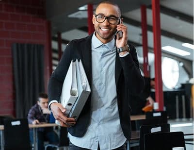Smiling man in business attire talking on phone at Hall's Sport Center.