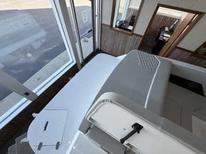 Inside boat cockpit with white seating and control console.