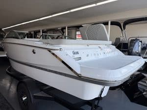 White bowrider boat on trailer inside showroom at Hall's Sport Center.