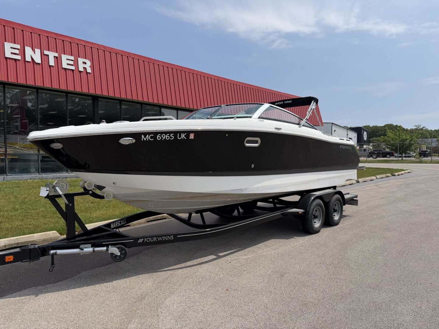 High-quality motorboat displayed on a trailer outside Hall's Sport Center, ideal for water sports an.
