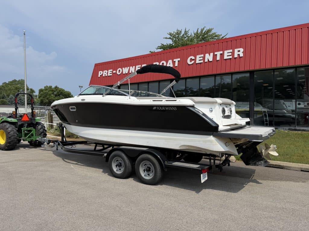 Used boat for sale at Hall's Sport Center, featuring a sleek black and white boat on a trailer.