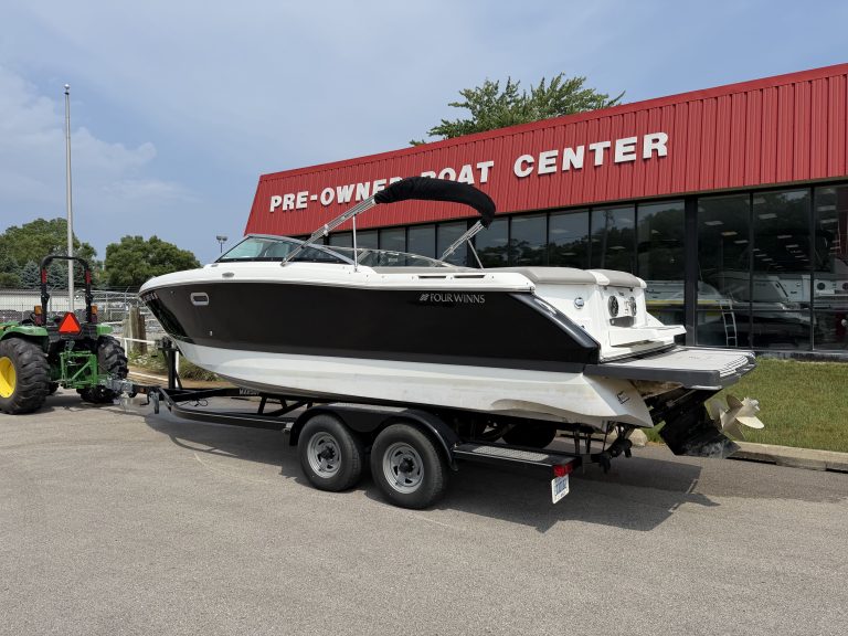 Used boat for sale at Hall's Sport Center, featuring a sleek black and white boat on a trailer.