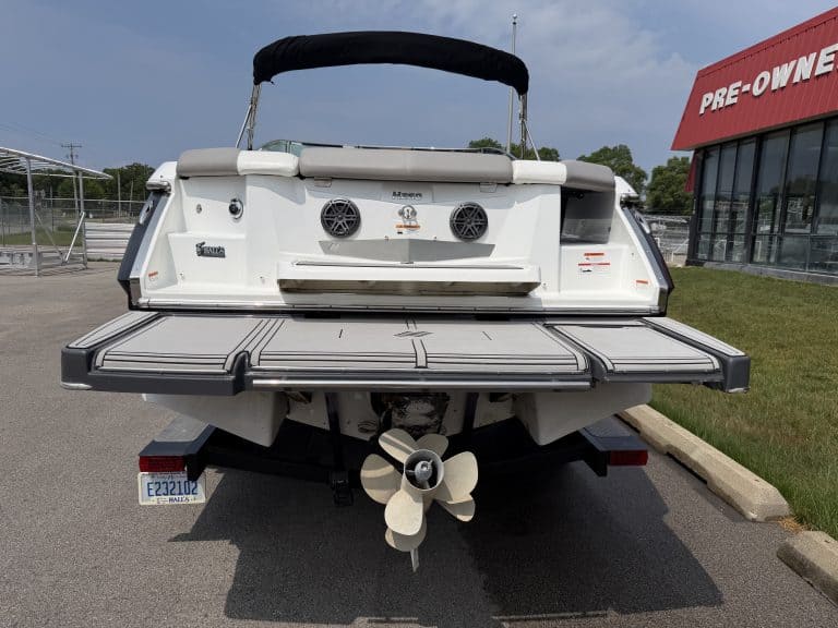 Boat with outboard motor parked outdoors at Hall's Sport Center.