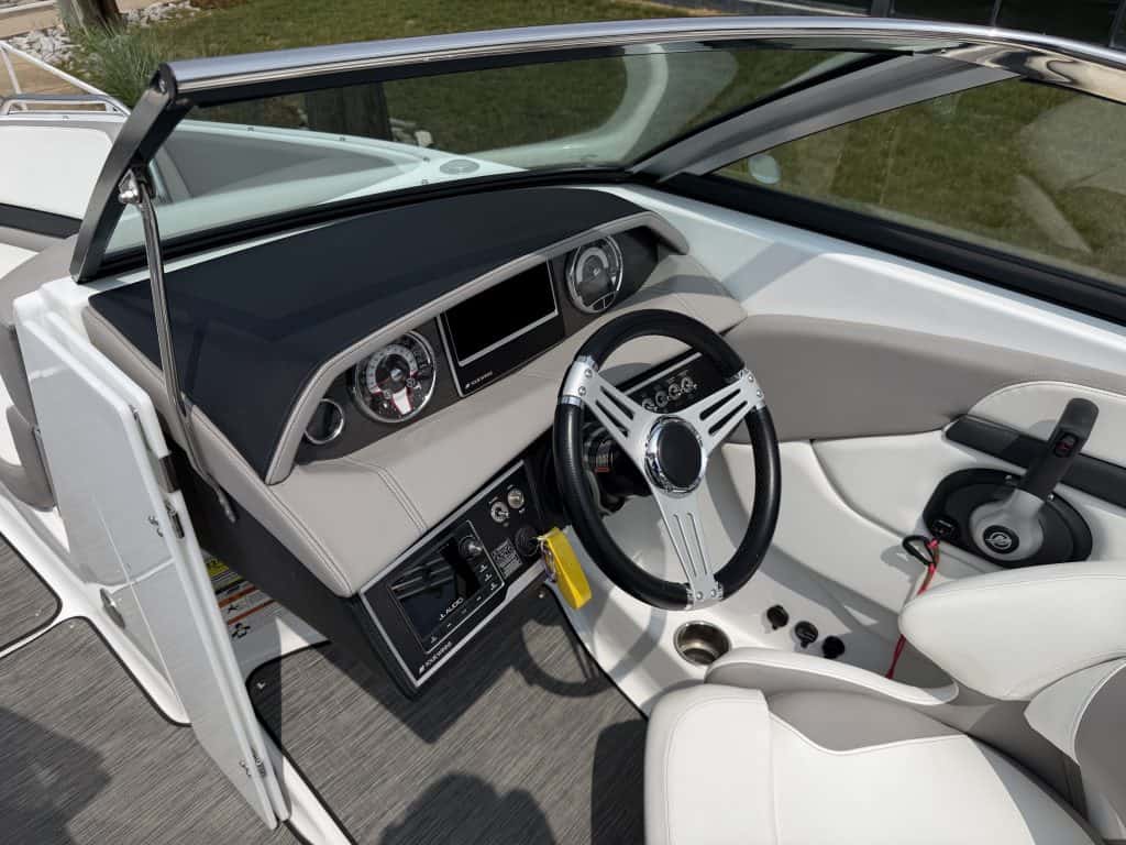 Boat helm with steering wheel, gauges, and control panel at Hall's Sport Center.